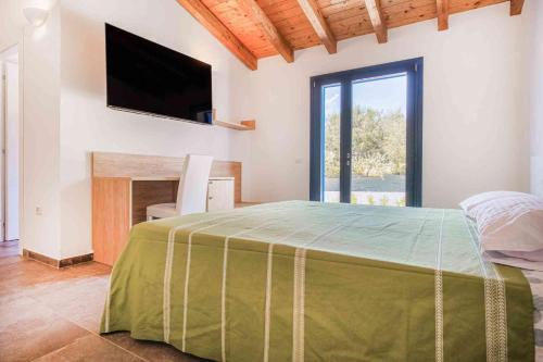 a bedroom with a bed with a television on the wall at Luxury Home La Cinta in San Teodoro