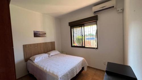 a small bedroom with a bed and a window at Mare Mansa Residence in Florianópolis
