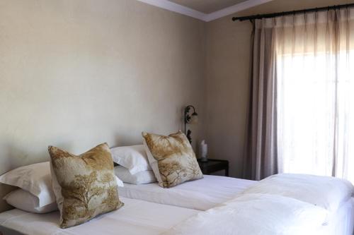 two beds in a bedroom with white sheets and pillows at Rietfontein 1888 in De Aar