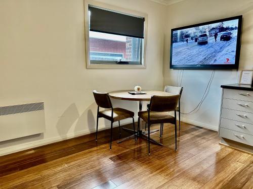 a dining room with a table and chairs and a tv at Entire Unit in Penguin with Free Parking in Penguin