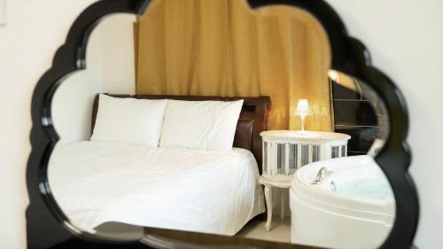 a bedroom with a bed and a mirror and a sink at Yangyang Monti Pet Spa Pension in Yangyang