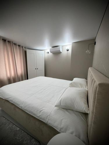 a bedroom with a large white bed and a couch at Casa in centrul Chisinaului in Chişinău