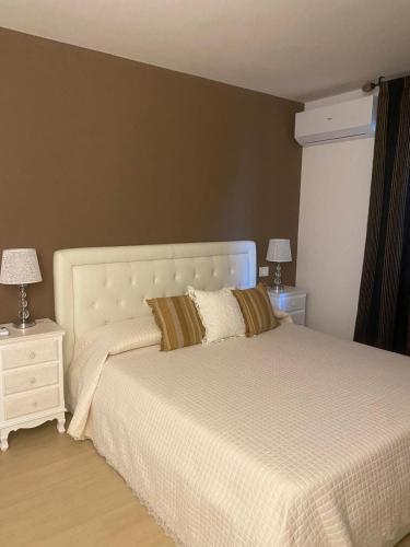 a bedroom with a white bed with two night stands at Casa Annadelia in Silvi Paese
