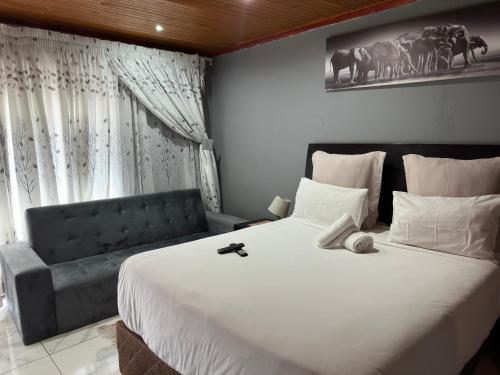 a bedroom with a large white bed and a window at K K K Guesthouse in Secunda