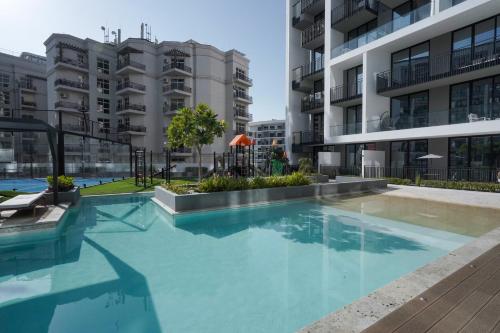 an empty swimming pool in an apartment building at Stylish modern studio near Miracle Garden with Gym, Pool and Padel court in Dubai