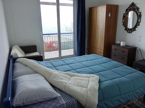 a bedroom with a large blue bed and a window at Akri Rooms in Akrata