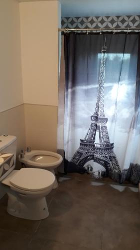 a bathroom with a toilet and a shower curtain with the eiffel tower at ELINOR-CASA PLAYERA - a 2 cuadras de la playa in Santa Clara del Mar