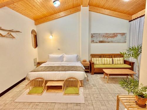 a bedroom with a bed and a couch and a table at 隱山居 海景包棟2-10人 in Jiufen