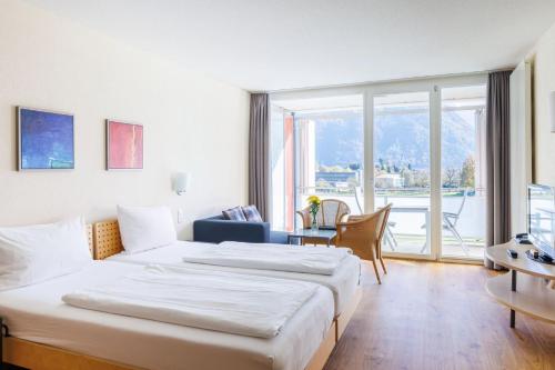 a hotel room with two beds and a large window at Hapimag Ferienwohnungen Interlaken in Interlaken