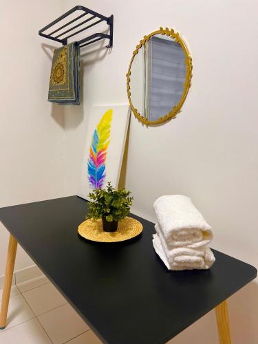 a black table with a plant and a mirror at AmyHana Cozynest in Putrajaya