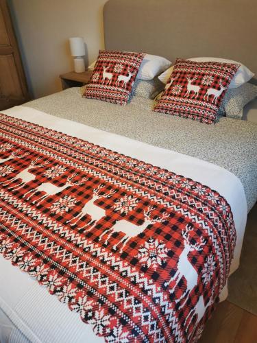 a bed with a red and black blanket on it at TheGilgahouse Gardenroom in Nakskov