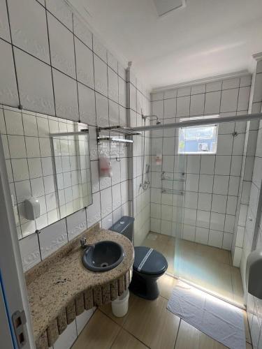 a bathroom with a sink and a toilet at Hoteis Cattoni Executive in Lages