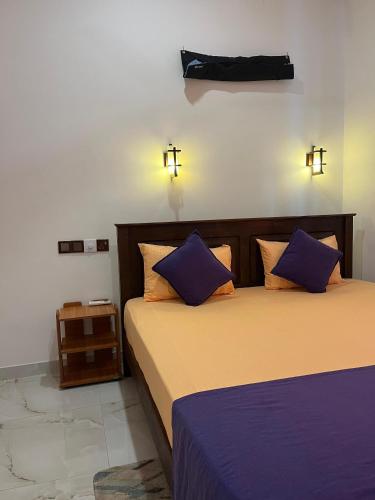 a bedroom with two beds with purple and orange pillows at Hide Hiriketiya Villa in Dickwella