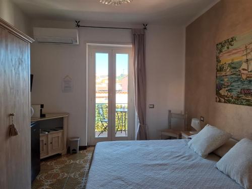 a bedroom with a bed and a sliding glass door at Da Ghjuannedda in Arzachena