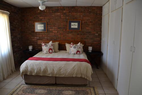 a bedroom with a large bed in a brick wall at Trout Ways in Waterval Boven