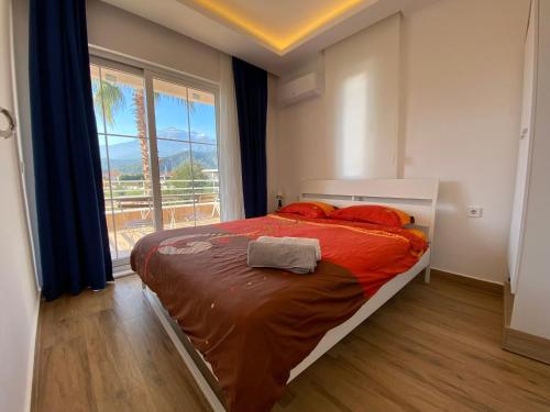a bedroom with a bed with red pillows and a window at Orange&Lemon Villas Çamyuva in Kemer