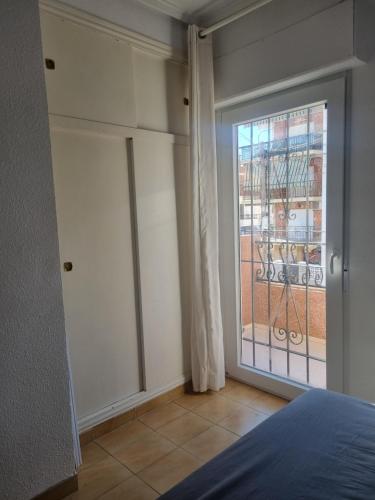 a bedroom with a sliding glass door with a balcony at Bungalow Monover Playa in Santa Pola