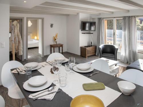 a dining room with a table and white chairs at Apartment Stem 2 by Interhome in Verbier
