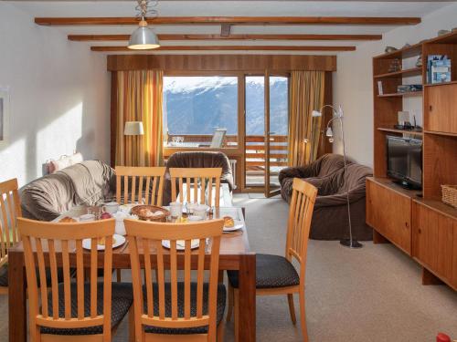 a dining room and living room with a table and chairs at Apartment Porthos 37 by Interhome in Verbier