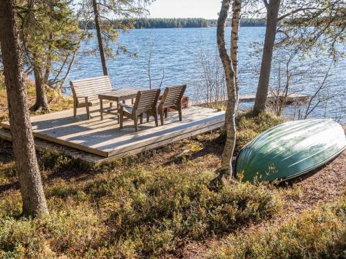 a table and chairs on a dock next to a boat at Holiday Home Putilanranta by Interhome in Saapunki
