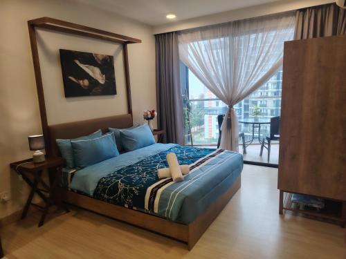 a bedroom with a bed and a large window at Timurbay Seafront By Moonlight Sea & Poolview in Kuantan