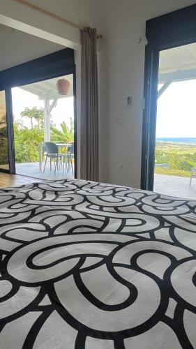 a room with a bed with a pattern on the floor at Lakay zot in Le Vauclin
