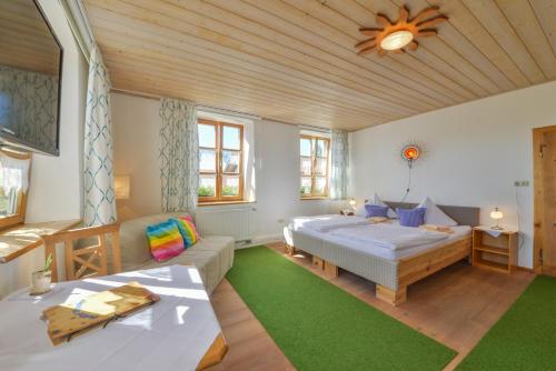 ein Schlafzimmer mit einem Bett und einem Sofa in einem Zimmer in der Unterkunft Gasthof Pritscher in Greilsberg