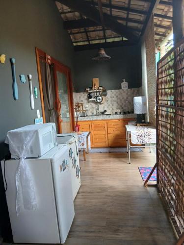 a kitchen with a white refrigerator in a room at Espaço Casa Palmar in Barra Grande