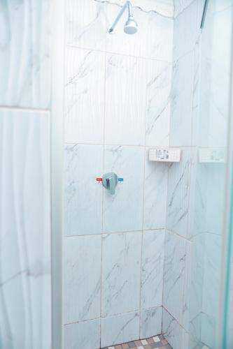 a bathroom with a shower with white marble tiles at Falcon Lodge PK in Bela-Bela