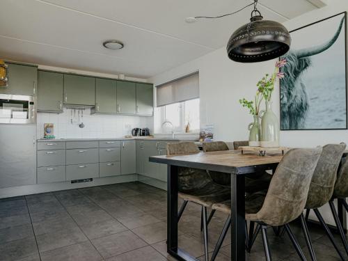a kitchen with green cabinets and a wooden table at Holiday Home Kraaijennest by Interhome in Uitgeest