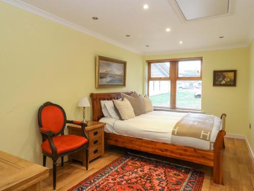 a bedroom with a bed and a chair and a window at 78 Findhorn in Forres