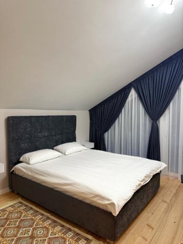 a bedroom with a large bed with a black headboard at Yaremche Soul House in Yaremche