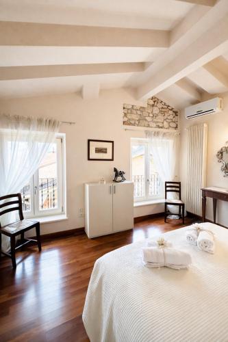 a bedroom with two beds and two windows at La Suite del Centro in Lazise