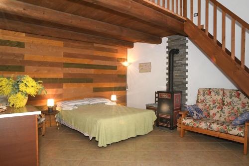 a bedroom with a bed and a staircase and a chair at B&B Le Mimose in Bricherasio
