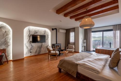 a bedroom with a king sized bed and a living room at Ephesus Select Suites in Kuşadası