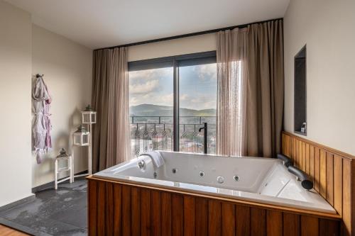 a large bath tub in a room with a window at Ephesus Select Suites in Kuşadası