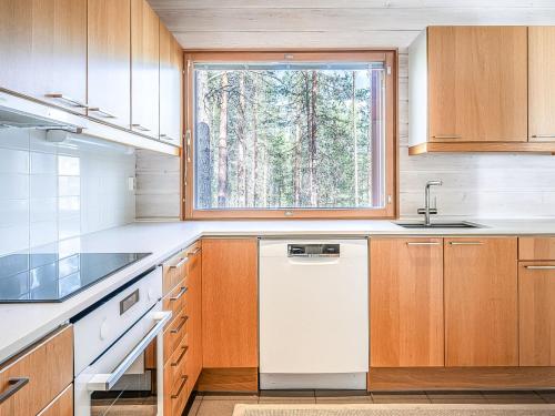 a kitchen with a window and a white dishwasher at Holiday Home Koukunmaja by Interhome in Kuusamo