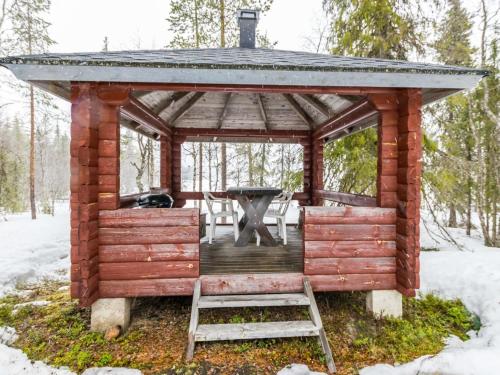 a wooden gazebo with a grill in the snow at Holiday Home Revontuli by Interhome in Ruka