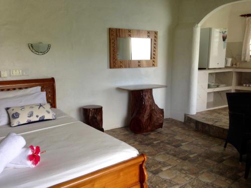 a bedroom with a bed and a table and a kitchen at Lazare Picault Hotel in Baie Lazare Mahé