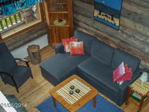 a living room with a blue couch and a table at Holiday Home Honkapirtti- vuotunki by Interhome in Kunnari