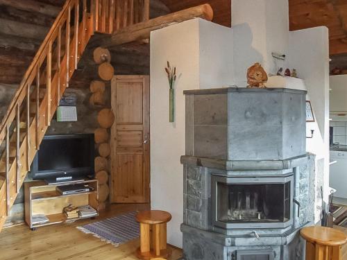 a living room with a fireplace and a tv at Holiday Home Honkapirtti- vuotunki by Interhome in Kunnari