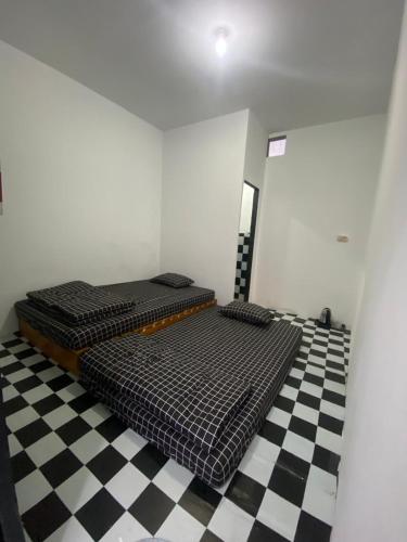 two beds in a room with a checkered floor at WD adventure Pangalengan in Palayangan
