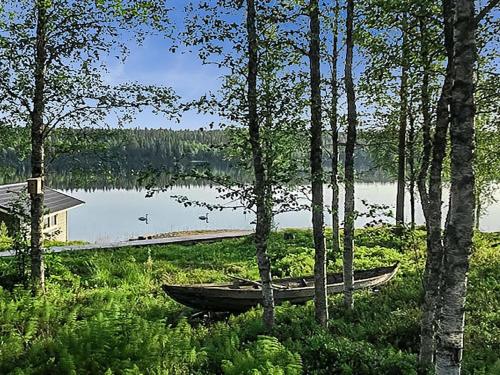 a boat sitting on the shore of a lake at Holiday Home Kallentupa by Interhome in Ruka