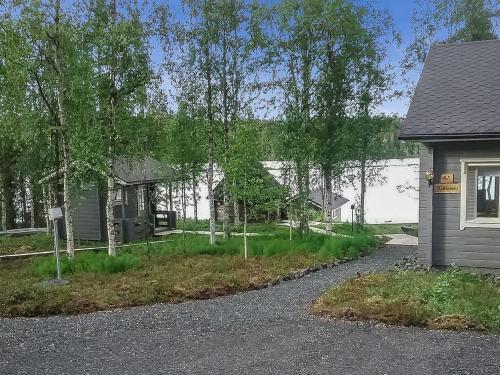 a house with a yard with trees and a driveway at Holiday Home Kallentupa by Interhome in Ruka
