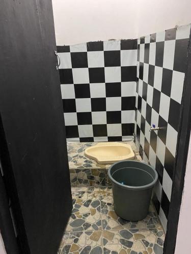 a bathroom with a checkered wall and a toilet at WD adventure Pangalengan in Palayangan