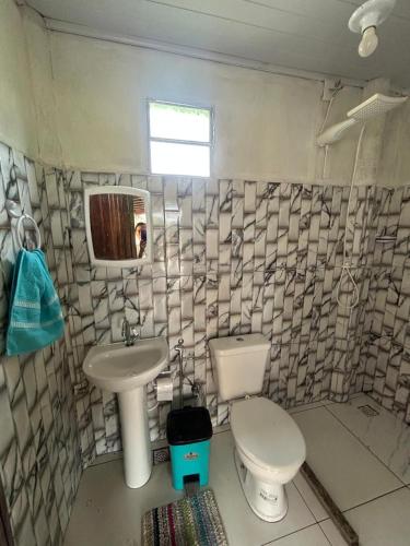 a bathroom with a toilet and a sink at casa passos e reis in Corumbau