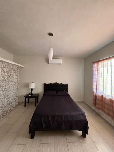 a bedroom with a bed with a black bedspread at Sagitario dpto in Tuxtla Gutiérrez