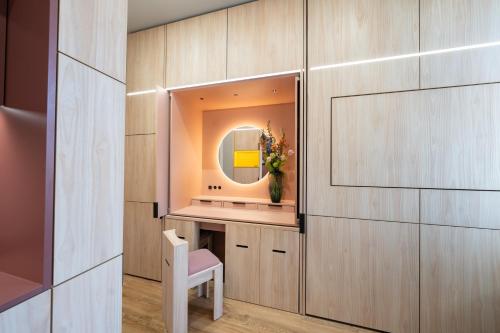 a dressing room with a mirror and a white chair at Homaris East Side - Self-Check In in Berlin