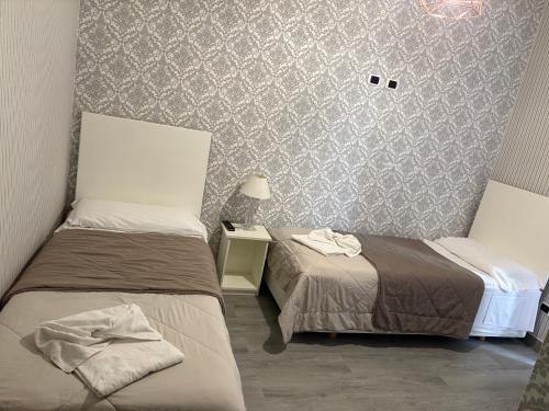 a room with two beds and a table with a lamp at Agriturismo il Casale in Ponte Galeria