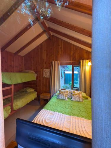 a bedroom with two bunk beds and a tv at Cabañas en Pucón CASA TUWA in Pucón